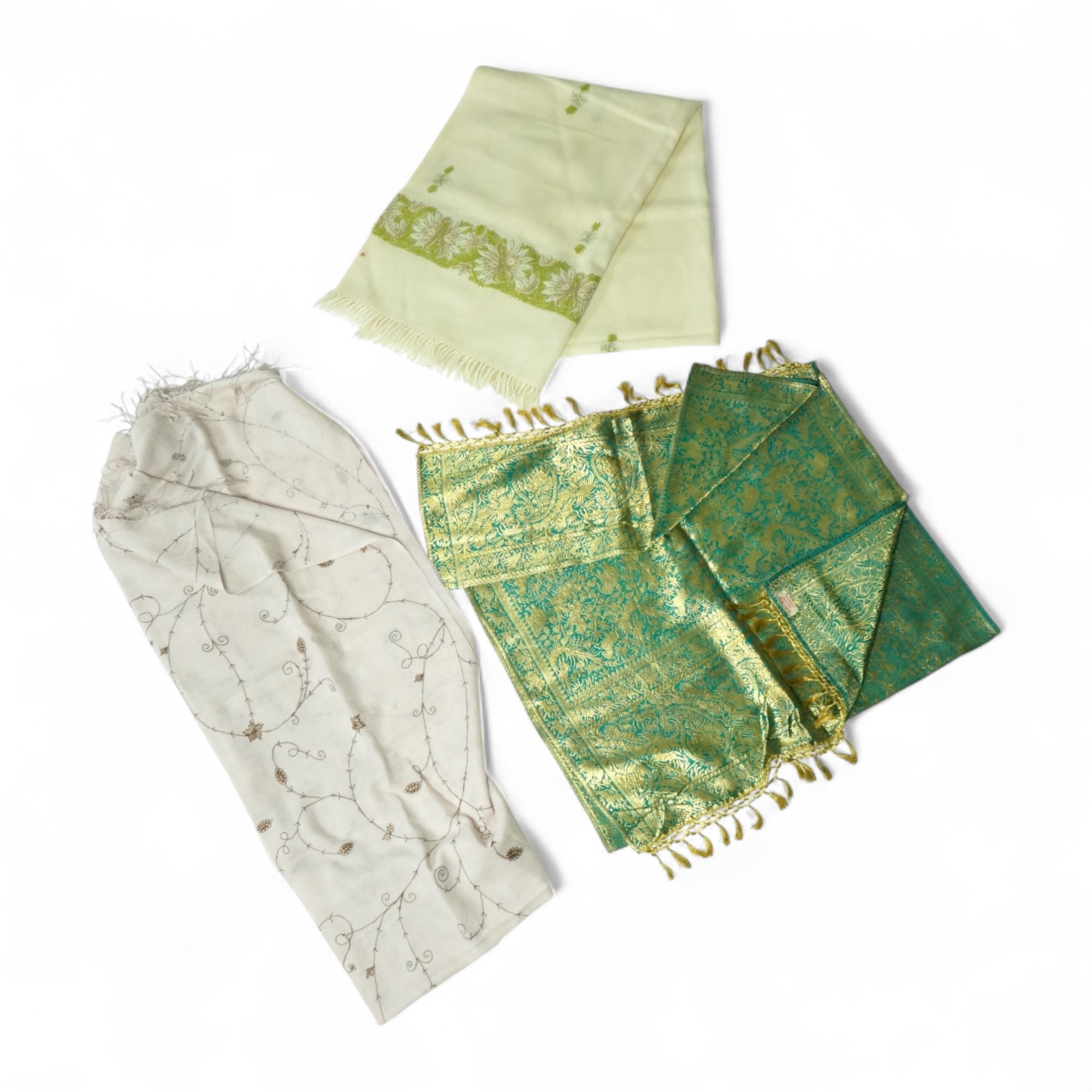 An Indian green and gold silk hand woven brocade stole, a cream pashmina embroidered stole and a similar finely woven and embroidered lilac stole (3). Brocade stole 38cm x 180cm., Condition - light stain to finely woven